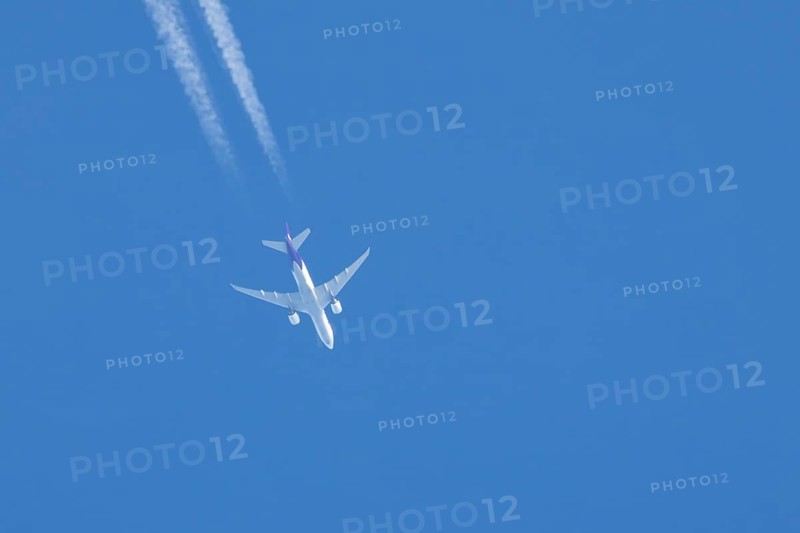 Airbus A300 jet aircraft of Fedex airlines flying in a blue sky with a vapor trail or contrail behind, England, United Kingdom, Europe
