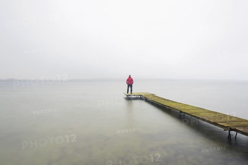 Man on wooden jetty at Großer Plöner See, Great Plön Lake, Lake Plön, Grosser Ploener See in winter, Schleswig-Holstein, Germany | MR:yes Arndt Sven Erik