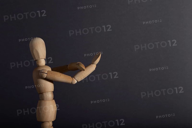 Wooden mannequin shows obscene gesture fuck off with hands on gray background. protest, riot, agression, contempt concept. copy space, hard light