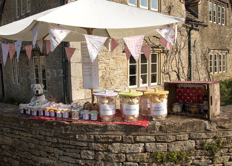 Dog and garden produce stall and street in the village of Lacock, Wiltshire, England, UK