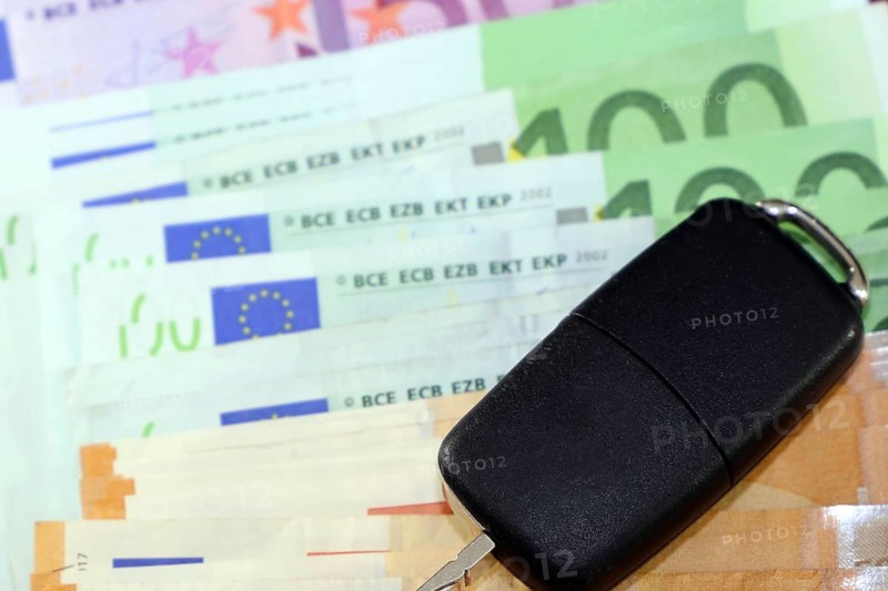 Euro banknotes and car keys as a symbol for car costs