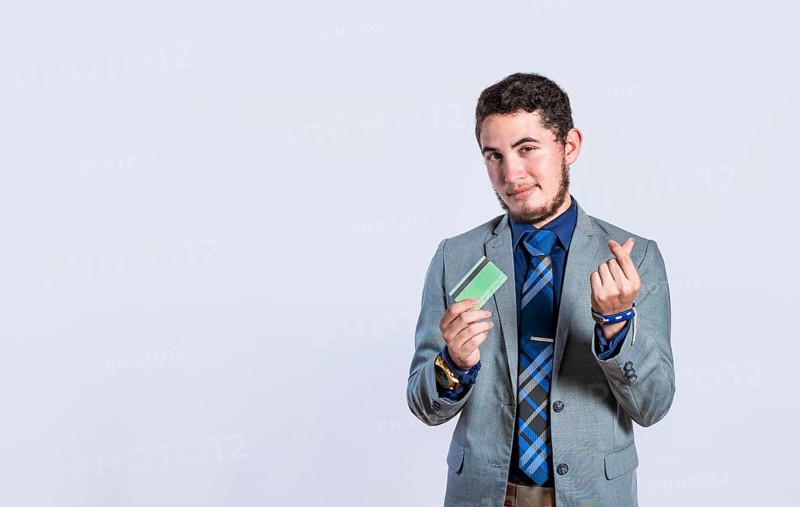 Smiling businessman holding credit card isolated. Business man holding credit card making money gesture with fingers. Concept of businessman with debit card