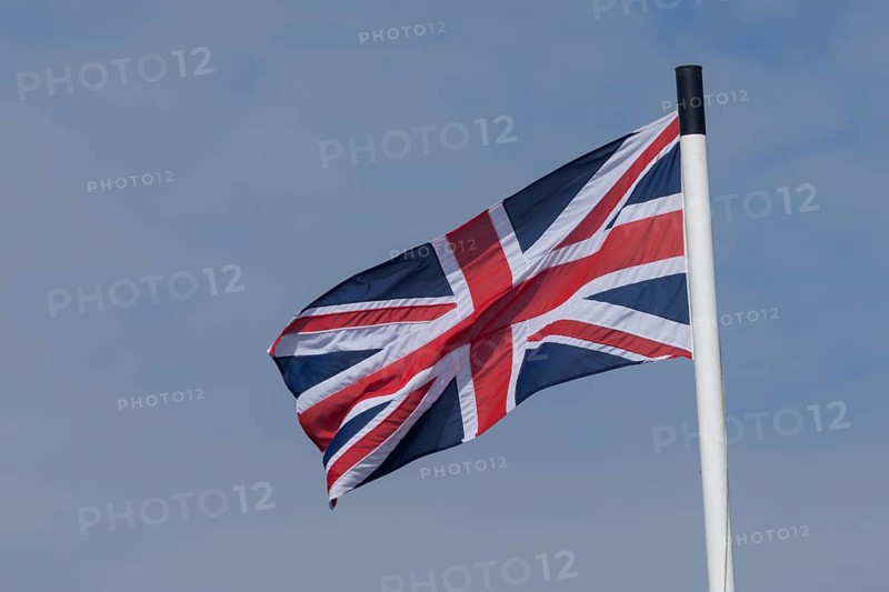 Union jack flag of the United Kingdom blowing in the wind against a blue sky, England, United Kingdom, Europe