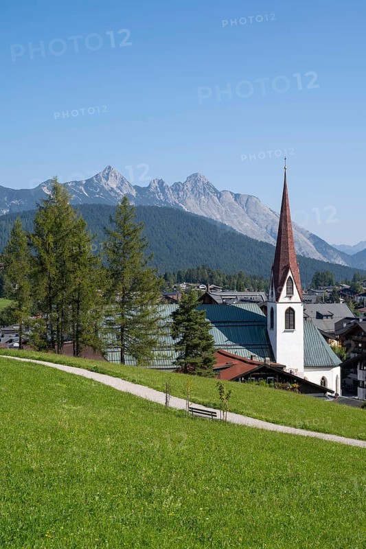 View of the village with St Oswald parish church, Karwendel mountains, view from the parish hill, Seefeld, Tyrol, Austria, Europe