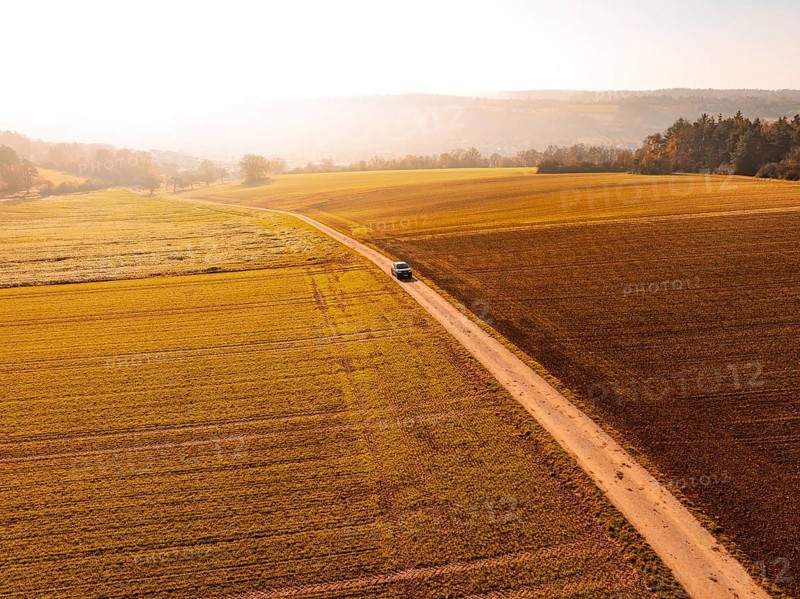 A car on a country lane, surrounded by wide, autumnal fields in soft light, electric car VW ID5, Deer Carsharing, Gechingen, Black Forest, Germany, Europe