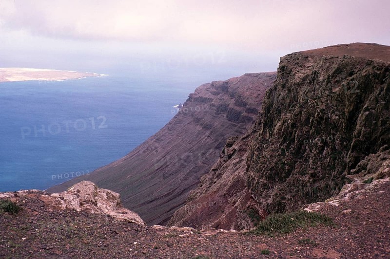 Steile Küstenklippen Risco de Famara mit Blick nach Norden auf die Insel Graciosa, Lanzarote, Kanarische Inseln, Spanien