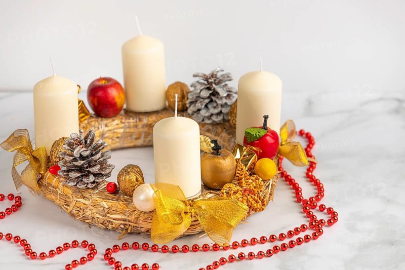 Christmas Advent wreath with white candles, golden decoration and red beads