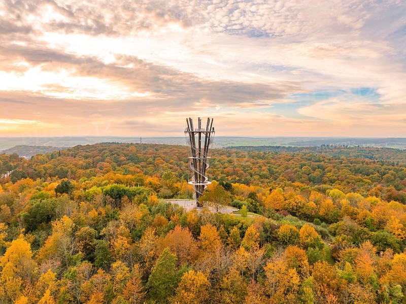 Imposing tower rises above the colourful autumn forest under a vibrant sky, Schönbuchturm, Herrenberg, Germany, Europe