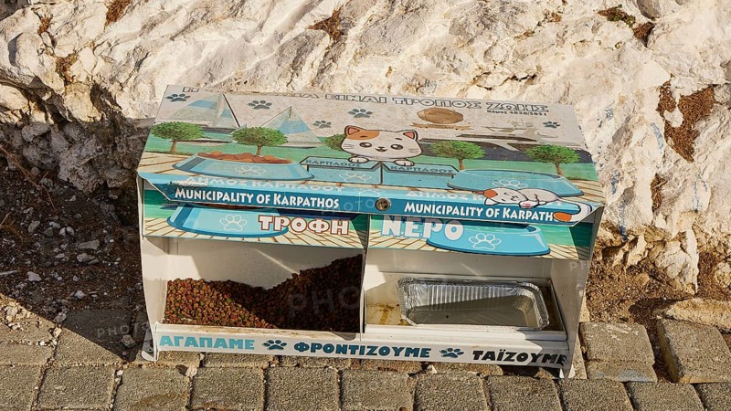 Food and water station for cats with decorative motifs, embedded in a sunny, stony environment, food box for cats, Pigadia, Karpathos, Dodecanese, Greek Islands, Greece, Europe