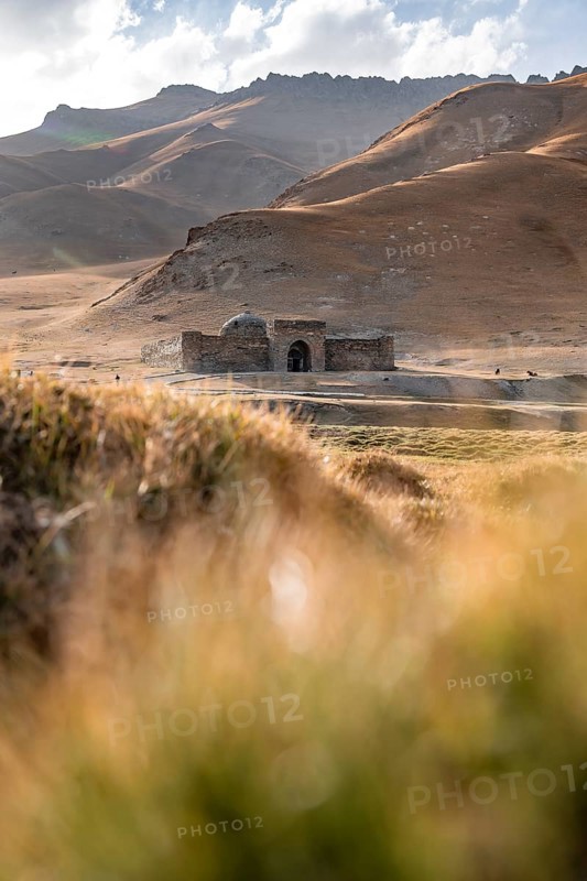 Historic caravanserai Tash Rabat from the 15th century, with yellow hills, Atbashy district in the Naryn region, Kyrgyzstan, Asia