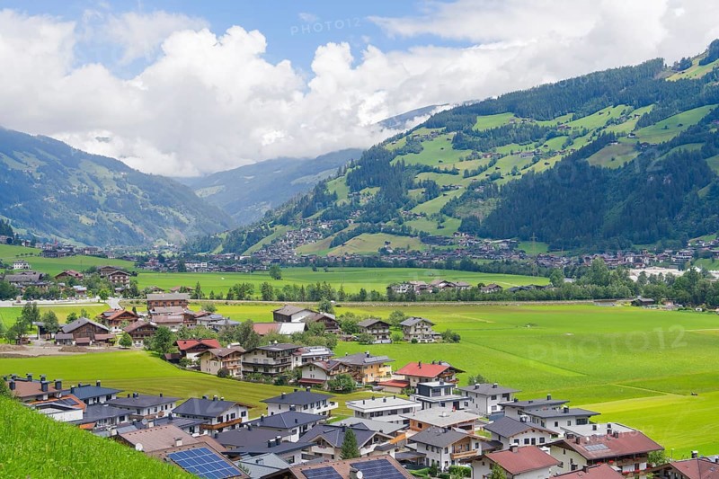 Alpine village with many houses and green hills, surrounded by majestic mountains, Mayrhofen, Zillertal, Austria, Europe