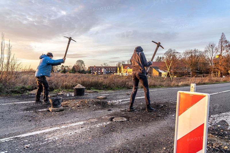 Climate activists chop up the asphalt of a road to erect obstacles, barricades, to prevent the police from evicting the occupied hamlet of Lützerath, the remains of the village are to make way for lignite mining, an eviction is imminent, North Rhine-Westphalia, Germany, Europe