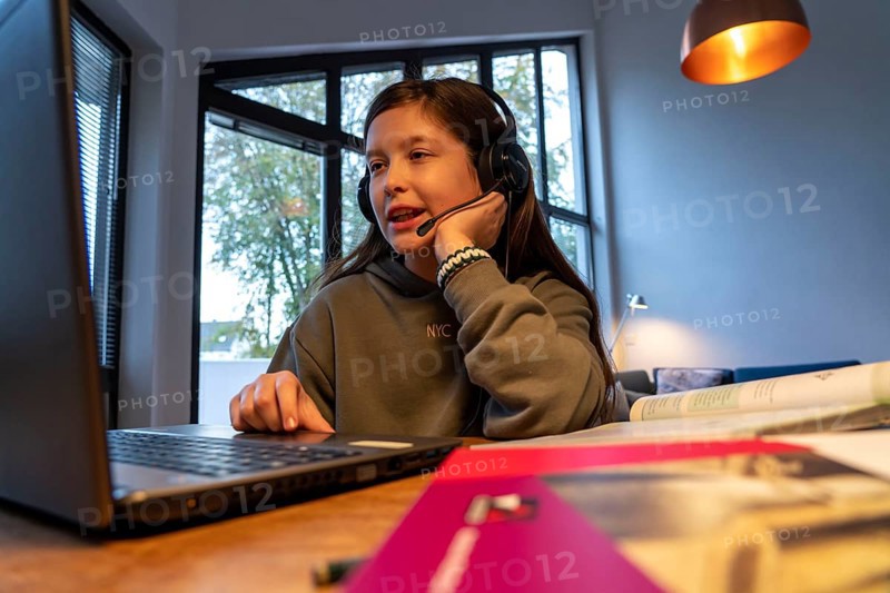 Homeschooling, girl, 11 years old, learns at home, home learning, lessons at home, distance learning, chat with teachers and classmates via laptop, symbolic image