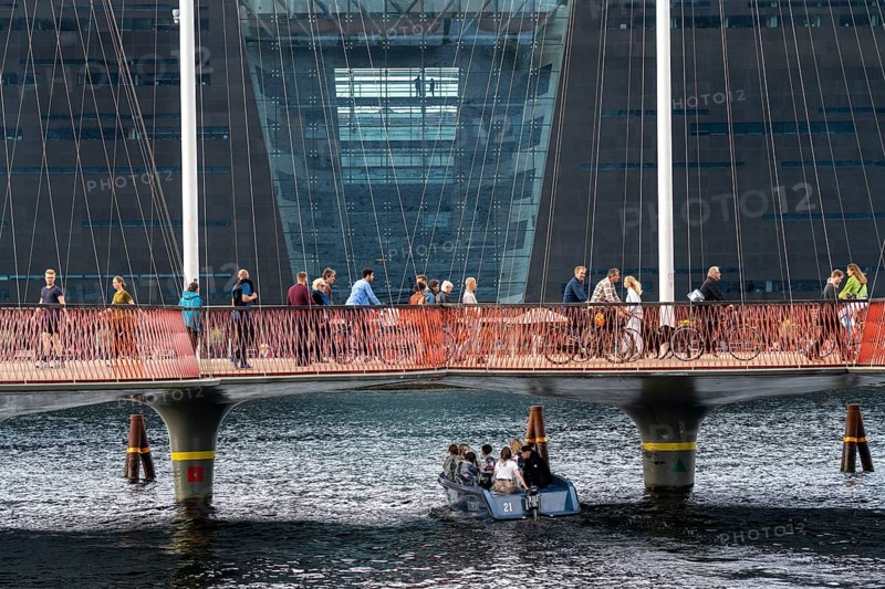 Cyclists on the Cirkelbroen cycle and footpath bridge, over the harbour, in the Christianshavens district, in the background the Danish Royal Library, Black Diamond, Copenhagen is considered the cycling capital of the world, 45 % of the population travel by bike, Denmark, Europe