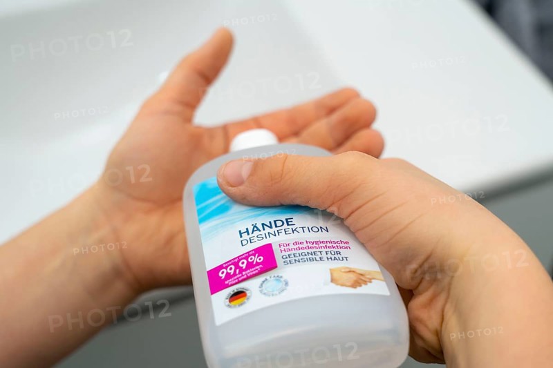 Domestic hygiene, sanitising hands with a hand sanitiser solution, boy 9 years old