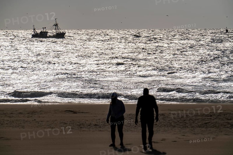 Strollers on the beach of Scheveningen, shrimp cutter, Netherlands