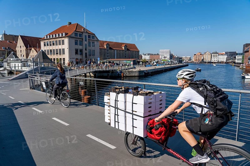 Cyclists on the Inderhavnsbroen cycle and footpath bridge, over the harbour, at Nyhavn, Copenhagen is considered the cycling capital of the world, 45 % of the population travel by bike, Denmark, Europe