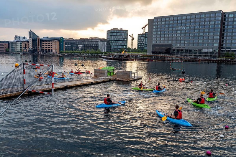 Summer evening in Copenhagen, at the harbour, Islands Brygge, people celebrating, eating, drinking, relaxing at the harbour shore, kayak polo, Denmark, Europe