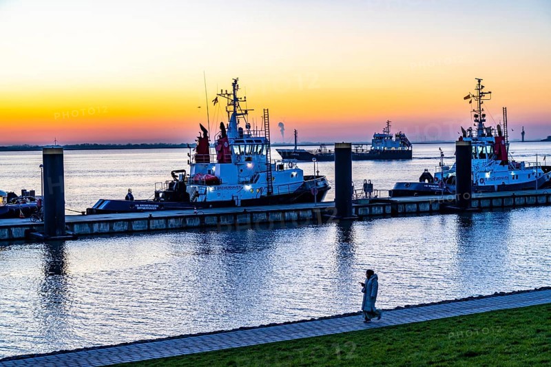 The tugboat pier, harbour tugs waiting for their next assignment, at the New Harbour, sunset over the Weser estuary with in Bremerhaven, Bremen, Germany, Europe