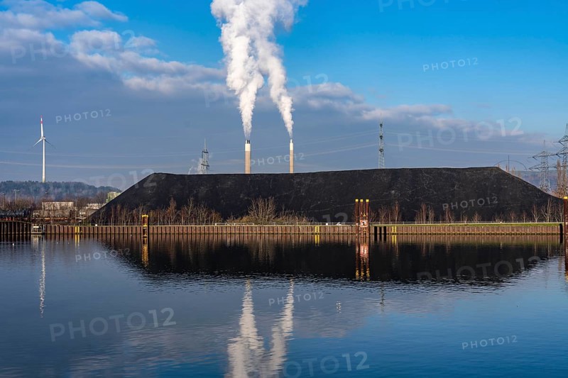 Coal stockpile, coal storage, steam coal, for the STEAG Herne thermal power station, in the background chimneys of AGR Abfallentsorgungs-Gesellschaft Ruhr Area, on the Rhine-Herne Canal, wind turbine on the Hoppennbruch stockpile, Herne, North Rhine-Westphalia, Germany, Europe