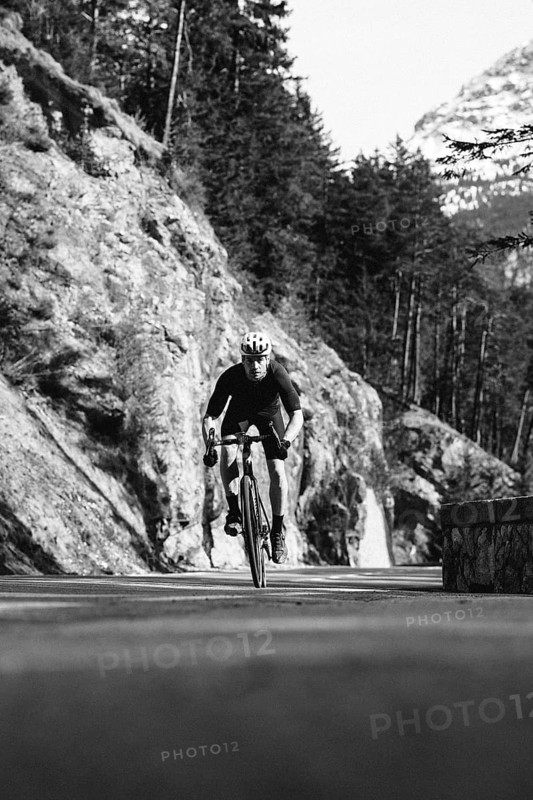 Road bike rider in spring between Lechtal and Tannheimer Tal in front of picturesque scenery of the Alps, Tyrol, Austria, Europe