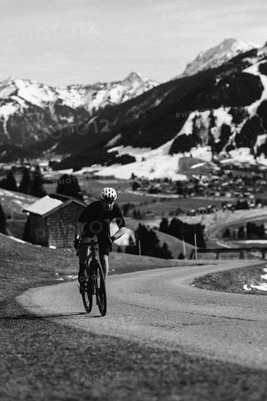 Road bike rider in spring in the Allgäu against the picturesque backdrop of the Alps, Bavaria, Germany, Europe