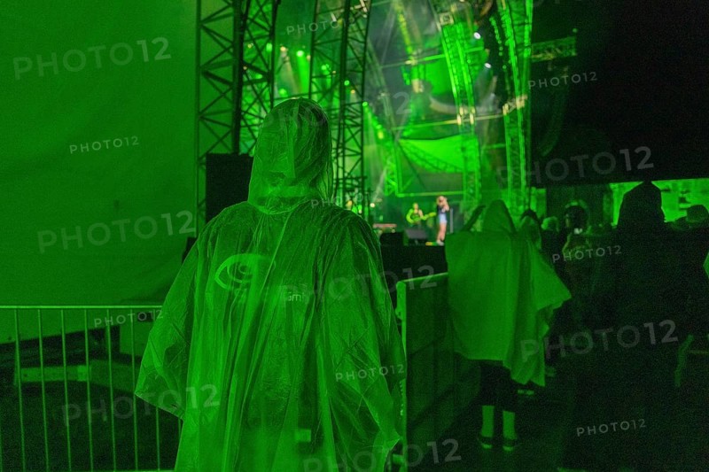 Person in green rain poncho at a night concert with green stage lighting, Klostersommer, Calw Hirsau, Black Forest, Germany, Europe