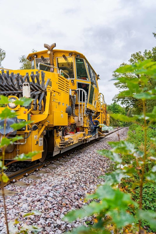 Yellow locomotive on rails, surrounded by trees and foliage, tamping machine, Hermann Hessebahn, Calw, Black Forest, Germany, Europe