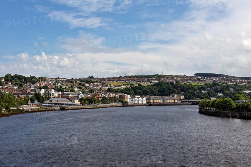 View over the river to the city with houses and blue sky, Londonderry