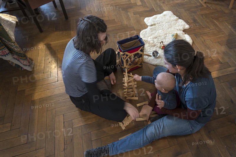 Young mother with her sister and with her son, 8 months, playing on the parquet floor, Mecklenburg-Vorpommern, Germany, Europe