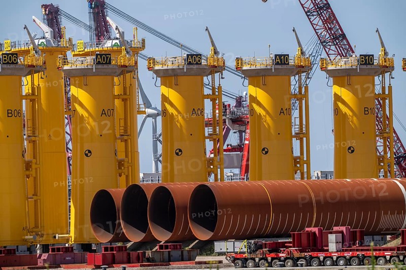 Transhipment centre for offshore wind turbines, which are transported here by the manufacturer and then shipped by special ships to the construction sites of the wind farms in the North Sea, here, yellow, so-called Transition Pieces Jackets, which are mounted on the monopile foundations driven into the seabed, on which the actual wind turbine is then mounted, in the port area of Vlissingen-Oost, Netherlands