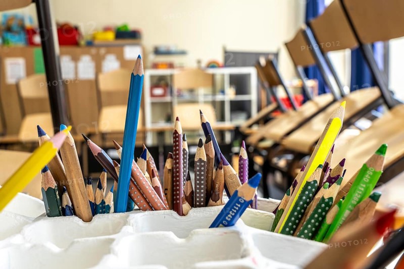 Classroom of a fourth grade, after school, the building is older but in good condition, coloured pencils