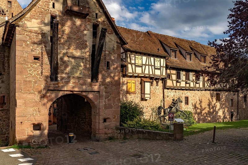 The upper gate La Porte Haute and half-timbered houses of the town wall of Riquewihr, Alsace, France, Europe