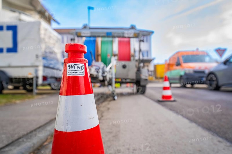 Traffic cone on a busy road with background traffic, Wend Glasfasermontage during the installation of conduits for fibre optic cables, Meßkirch, district of Sigmaringen, Germany, Europe