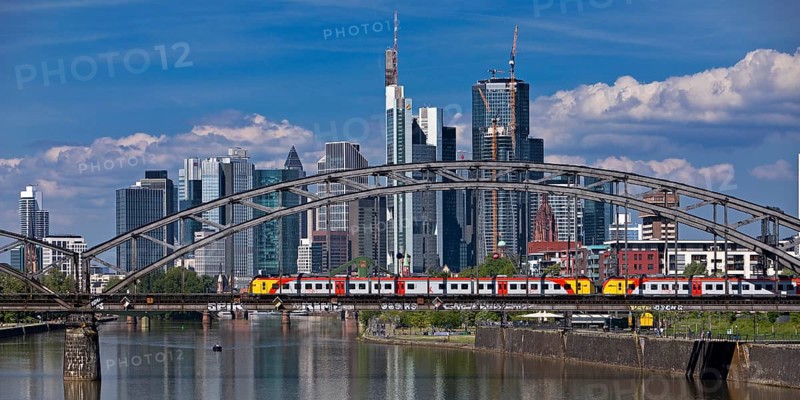 The river Main with regional railway on the Deutschherrnbrücke and the skyline of Frankfurt am Main, Hesse, Germany, Europe