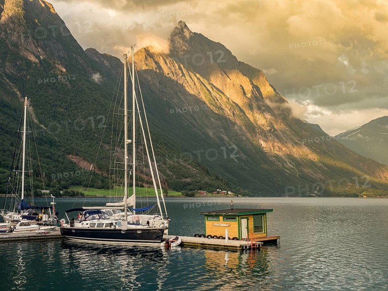 Boats and floating sauna, marina of village Urke at the Hjørundfjord, Mt. Slogen in the back, sunset, Norway, Europe
