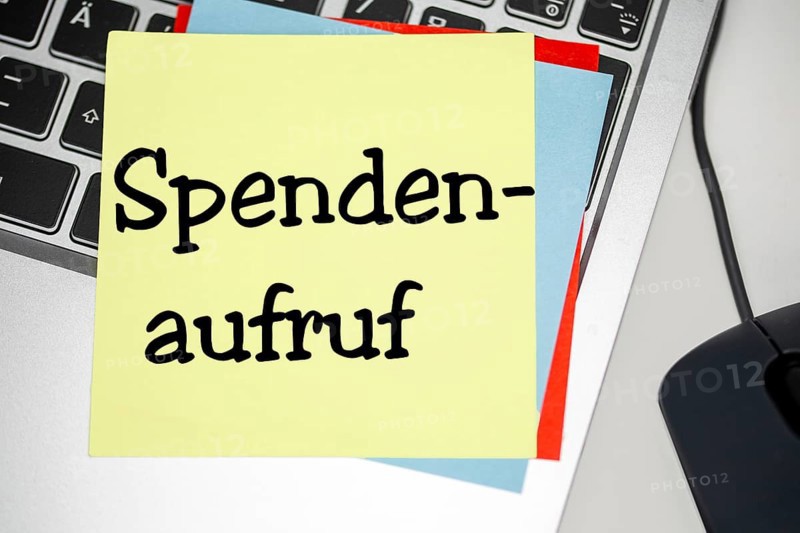 Notepad with the inscription SPENDENAUFRUF on a laptop