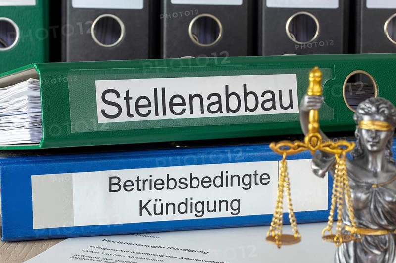 Cancellation in front of folders labelled STELLENABBAU and BETRIEBSBEDING KÜNDIGUNG (symbolic image)