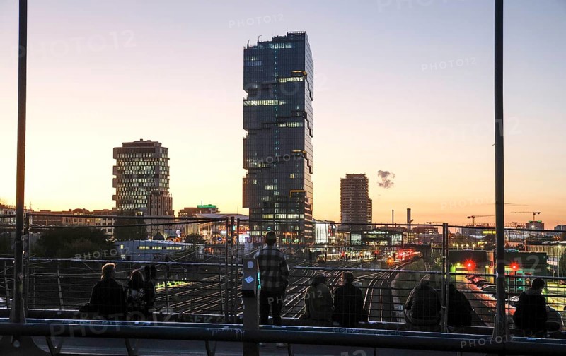 Chilling out at sunset on the Modersohn Bridge, view of railway tracks, trains and the 140 metre high Amazon office tower Edge East Side, Berlin, 23.10.2024., Berlin, Berlin, Germany, Europe