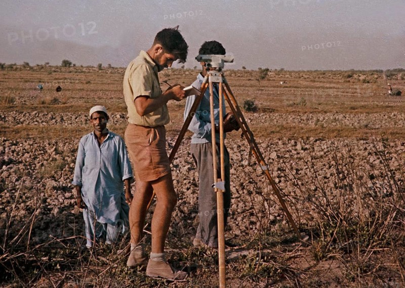 A Western European surveyor works on a technical project in rural Pakistan 1962