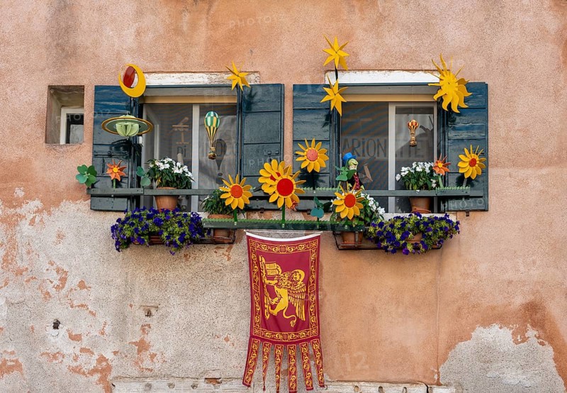 Windows decorated with flowers on a house facade, Venetian flag, Venice, Veneto, Italy, Europe