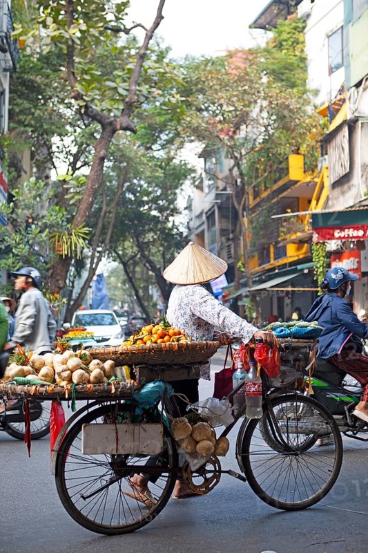 Vietnamese street vendor with conical hat and bicycle in the Old Quarter of Hanoi, Vietnam, Asia