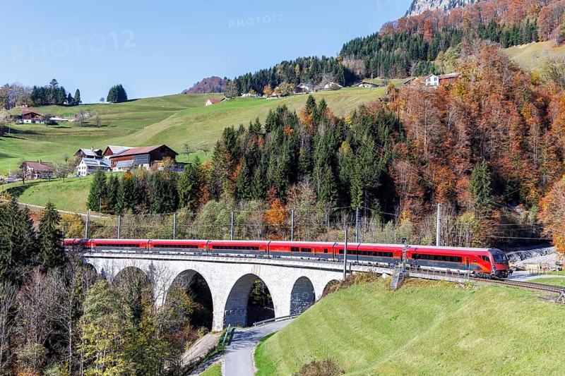 Railjet railway passenger train of the Austrian Federal Railways ÖBB on the Arlbergbahn in autumn in the Alps in Dalaas, Austria, Europe