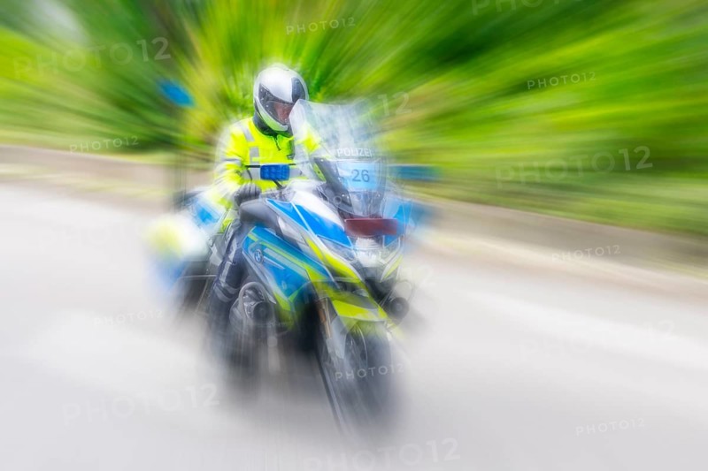 Policeman on a motorbike driving fast along the road, the speed is emphasised by the motion blur, Stuttgart, Baden-Württemberg, Germany, Europe