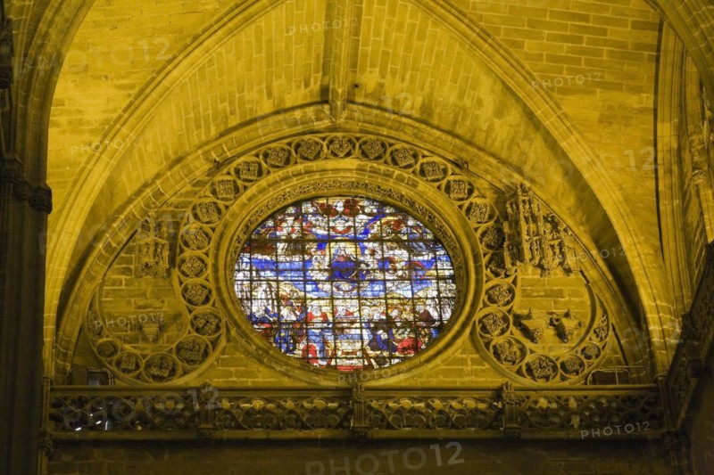 Stained glass rose window and architectural details in interior of The Cathedral of Saint Mary of the See or Seville Cathedral, Seville, Spain, Europe