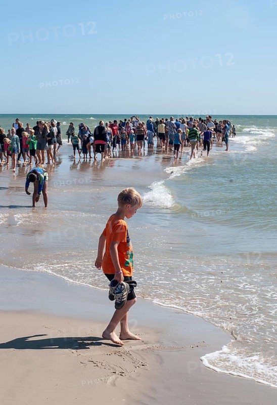 Ttourists standing at the northern tip of Denmark where the Baltic Sea and North Sea meet at Skagen Reef, Skagen gren, Jutland, Denmark, Scandinavia, Europe