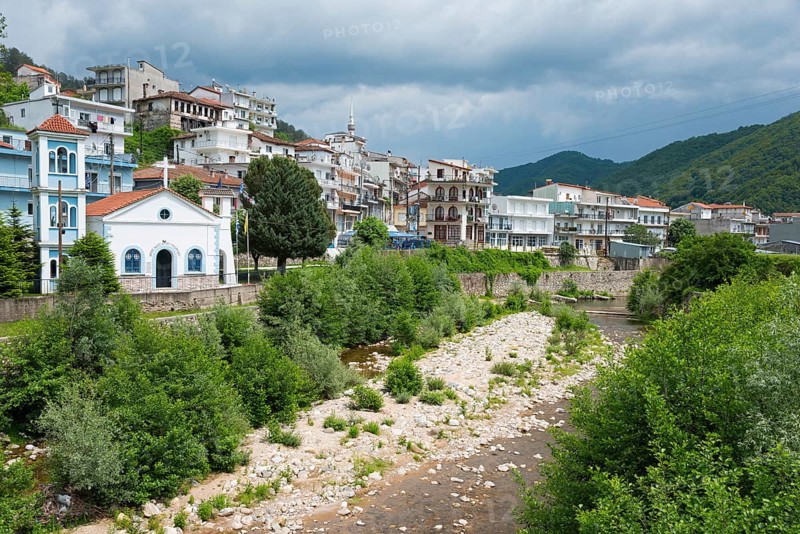 View of a small town with a river in the foreground, surrounded by wooded mountains and cloudy sky, Echinos, centre of the Pomaks, Myki, Xanthi, Eastern Macedonia and Thrace, Greece, Europe