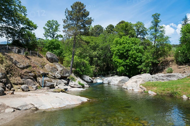 Ein ruhiger Fluss, der zwischen Felsen und einem grünen Wald fließt, schafft eine friedliche und natürliche Atmosphäre, Piscinas naturales, natürliche Pools, Schwimmbad, Arenas de San Pedro, Fluss Arenal, Ávila, Avila, Kastilien-León, Kastilien-Leon, Spanien