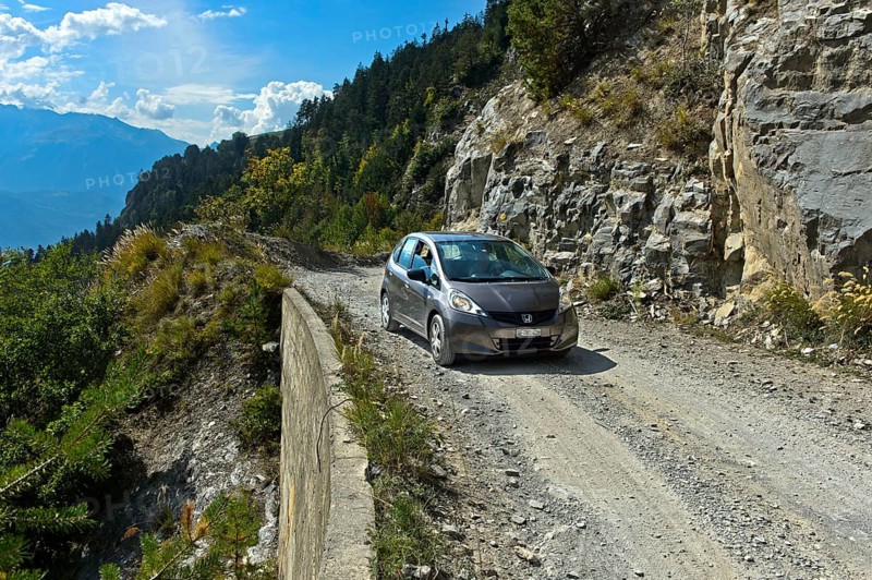 Car travelling on the unpaved mountain road between Ovronnaz and the hamlet of Chiboz, Valais, Switzerland, Europe