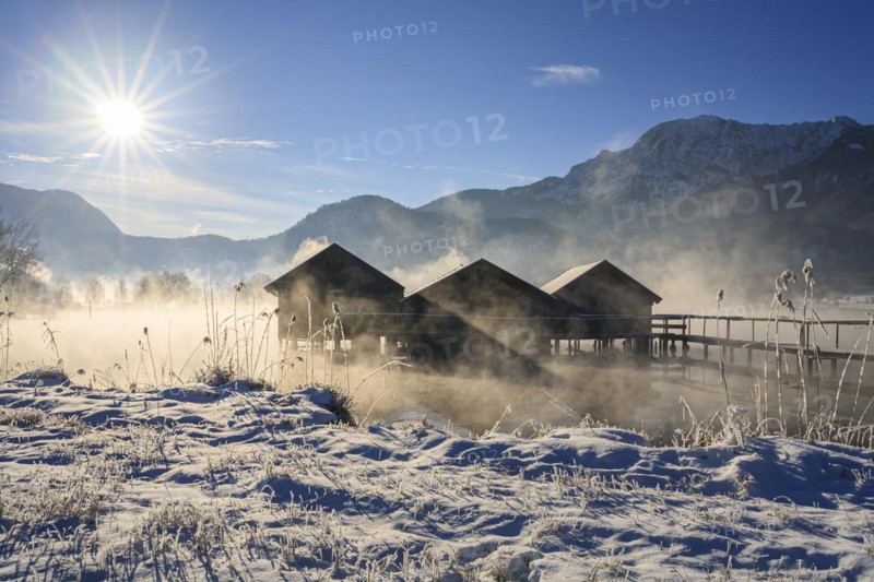 Boat huts in the morning light in front of mountains, lake, snow, sunbeams, winter, fog, Lake Kochel, foothills of the Alps, Bavaria, Germany, Europe